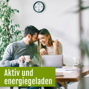 Ein lächelndes Paar sitzt an einem Tisch mit einem Laptop und Kaffeetassen und lehnt sich glücklich aneinander. Im Hintergrund sind eine Uhr und eine Pflanze zu sehen. Der Text auf Deutsch lautet: Aktiv und voller Energie – dank des pflanzlichen Vitamin-B-Komplexes (Bio) von gse.organic.supplements, Ihrem hochwertigen Bio-Nahrungsergänzungsmittel.